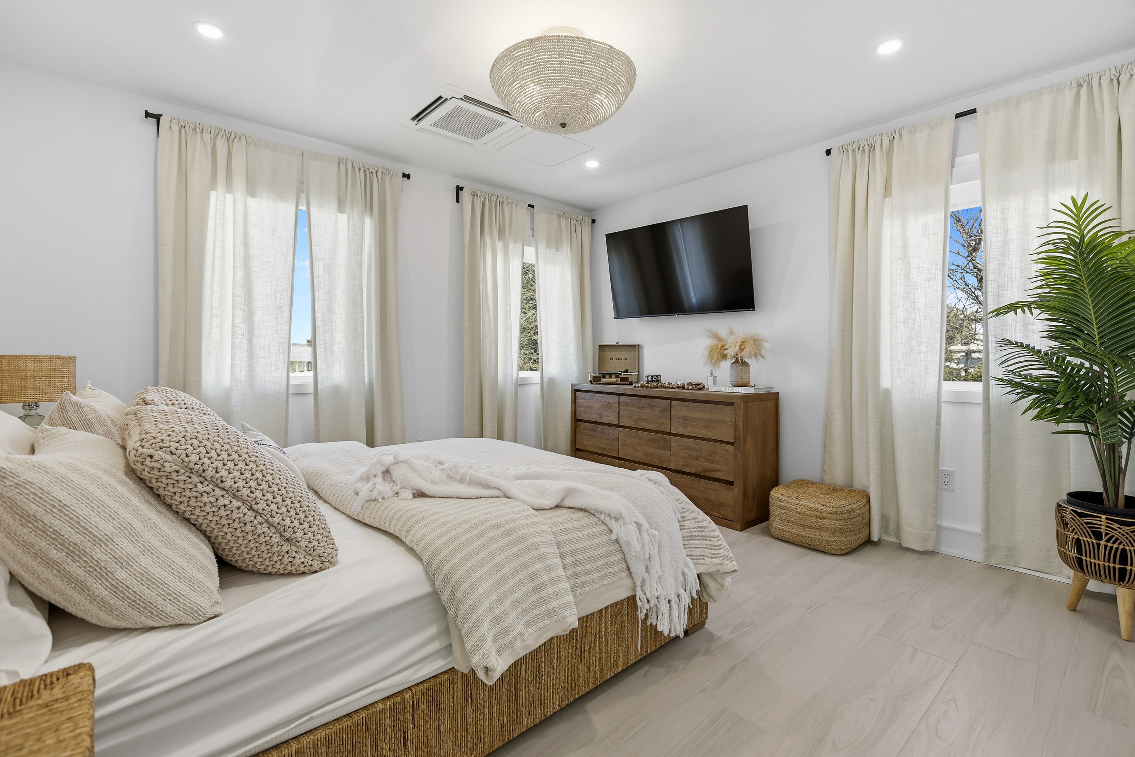 Master bedroom with coastal décor, tile floors, and natural light