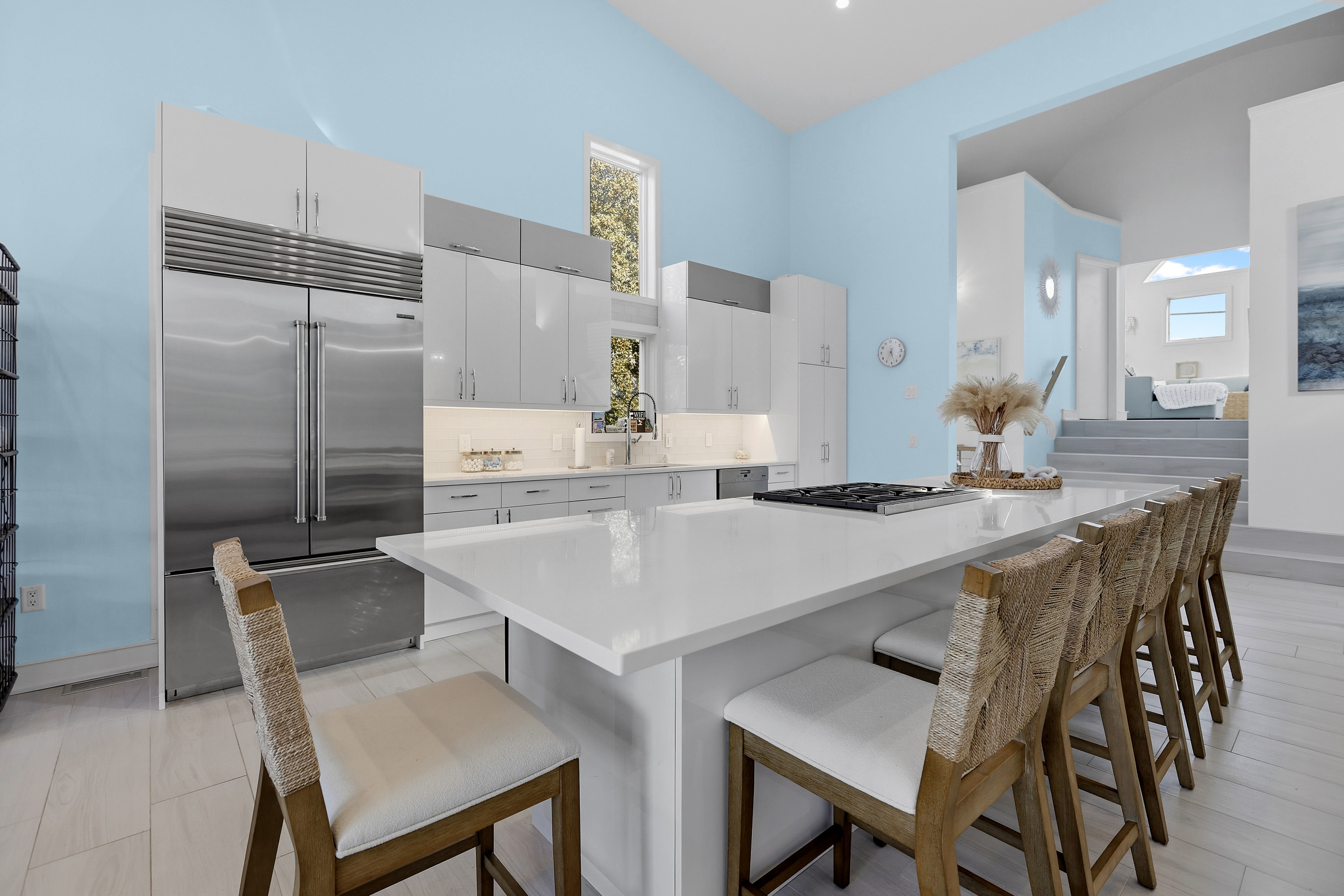 Renovated kitchen with quartz island, grey cabinetry, and Sub-Zero refrigerator