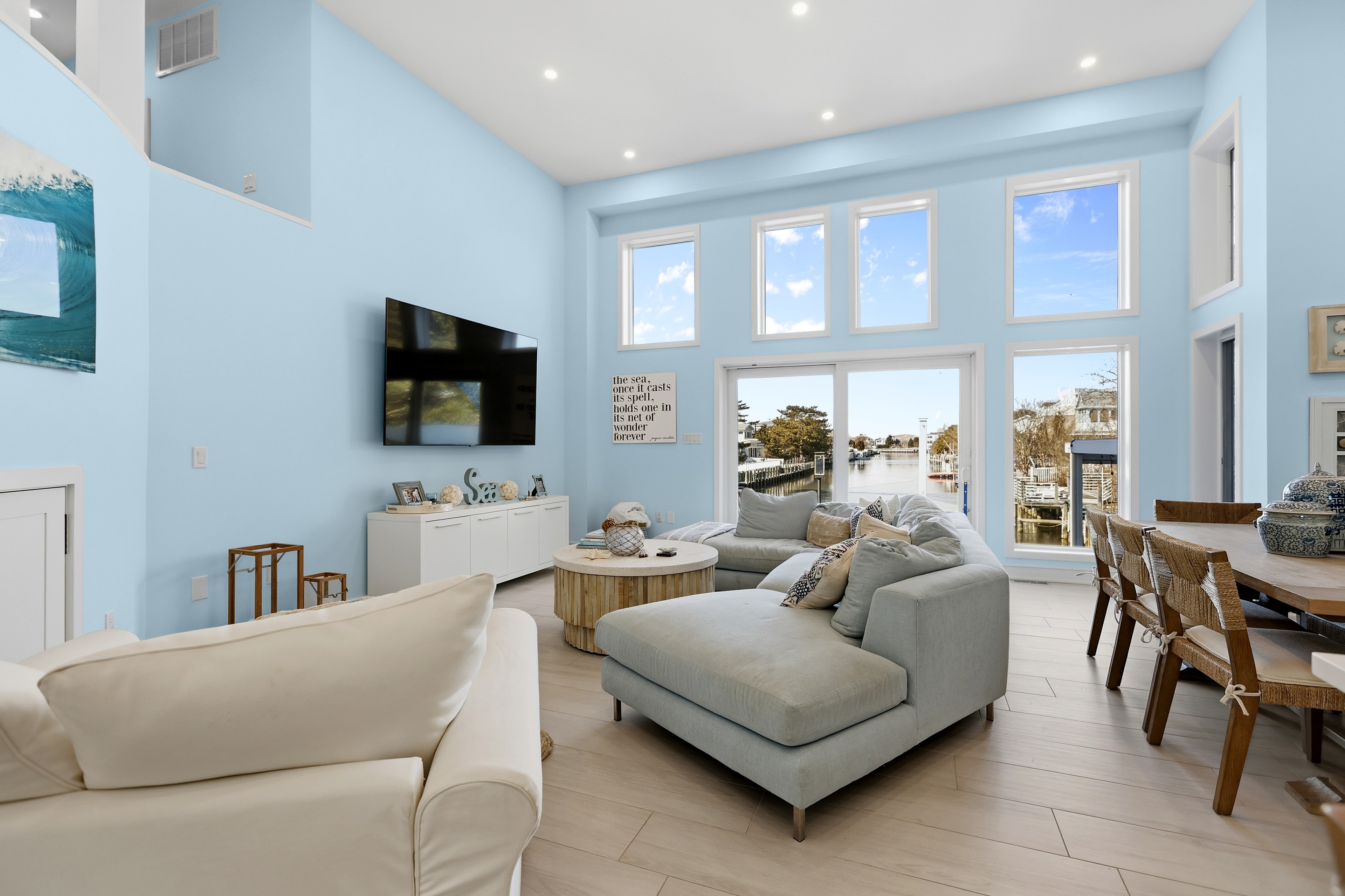 Open living room with vaulted ceilings, light blue walls, and waterway views