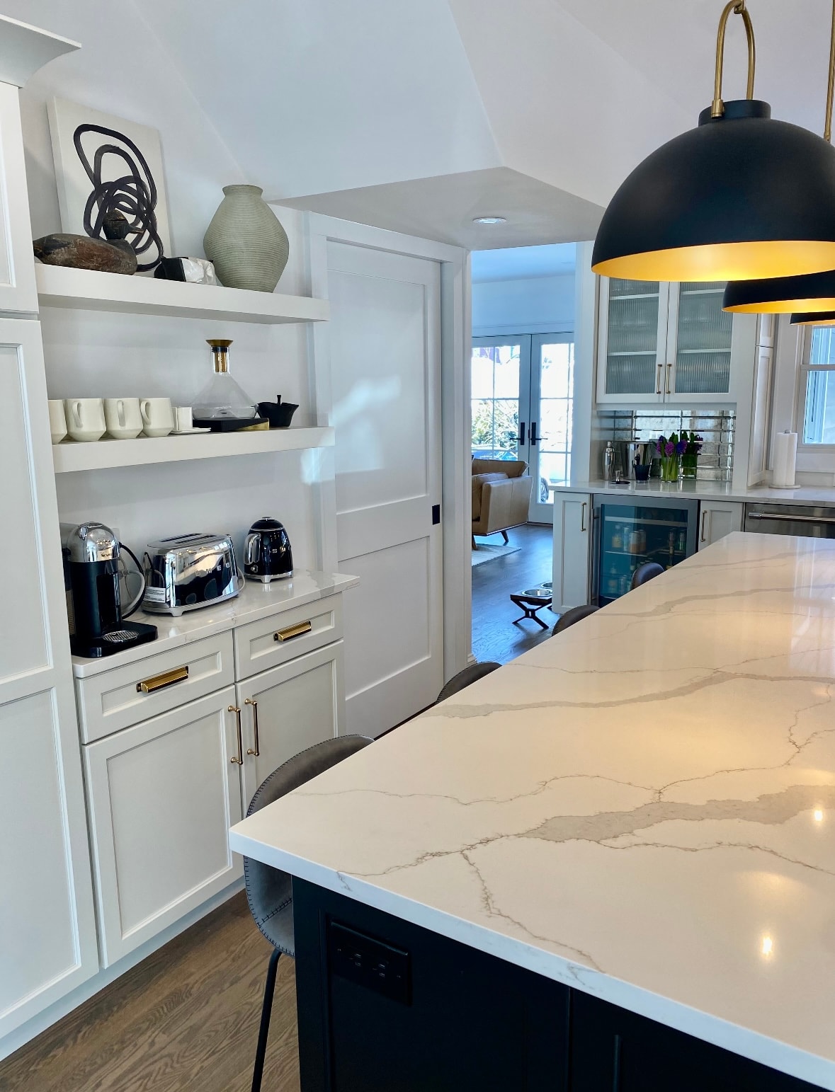 Custom kitchen with quartz island, open shelving, and black pendant lighting