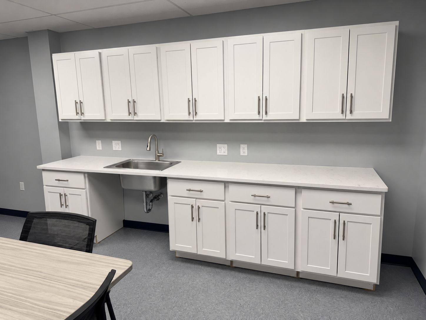 S2S laboratory center break room with white shaker cabinets, quartz countertops, and stainless steel sink